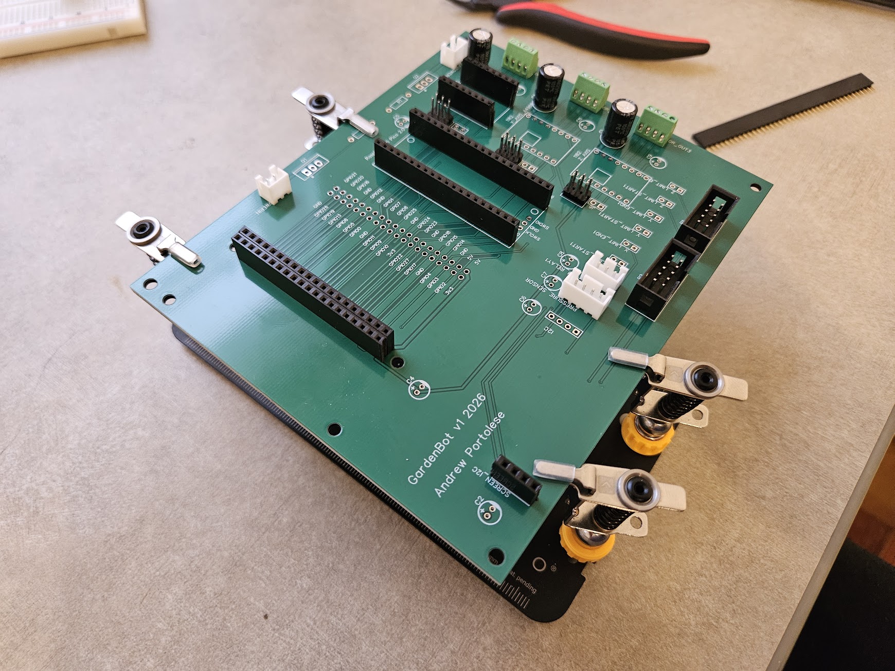 GardenBot v1 PCB mid-assembly with connectors, screw terminals, and pin headers soldered in place